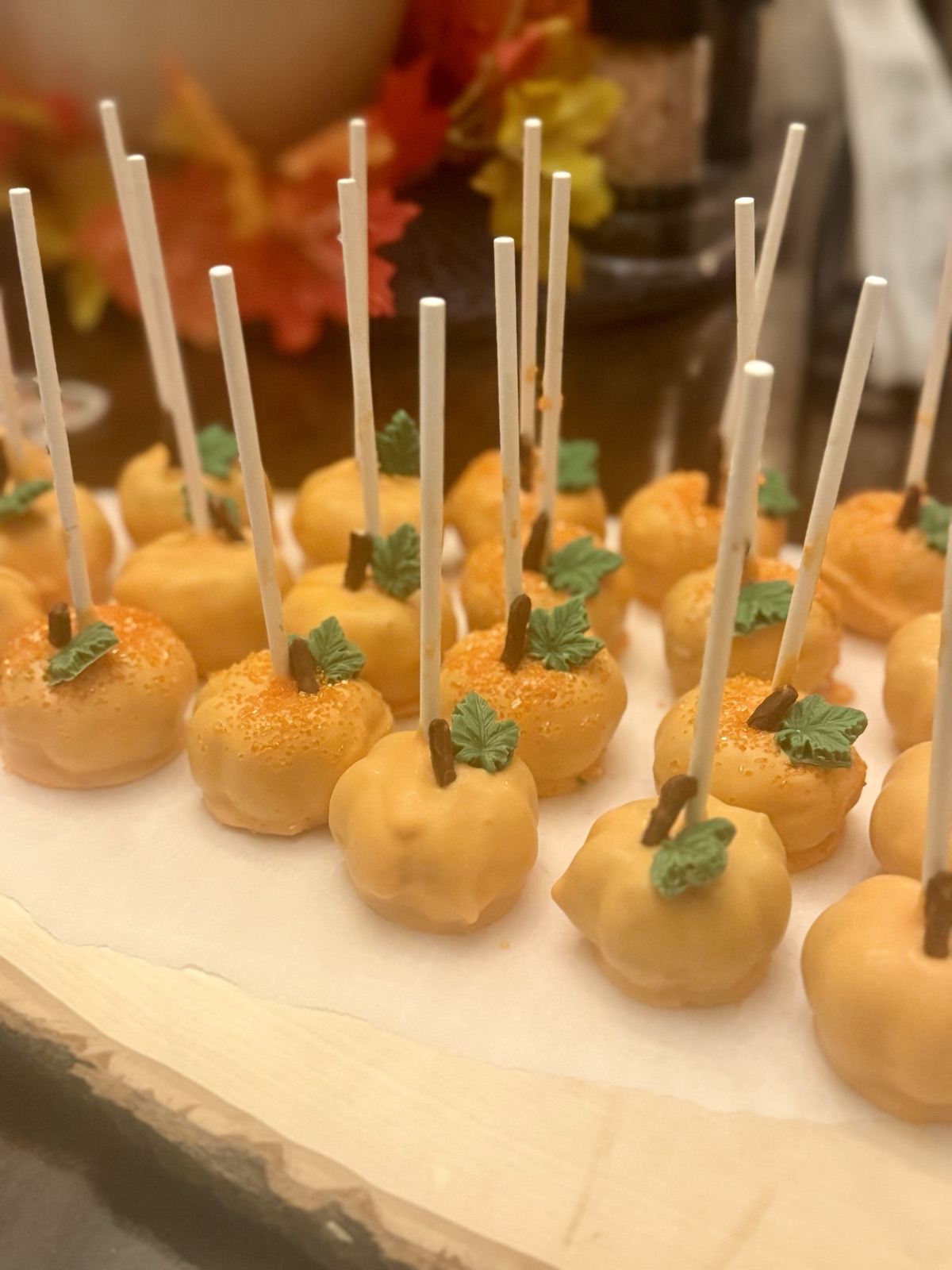 Pumpkin shaped cake pops with leaf sprinkles